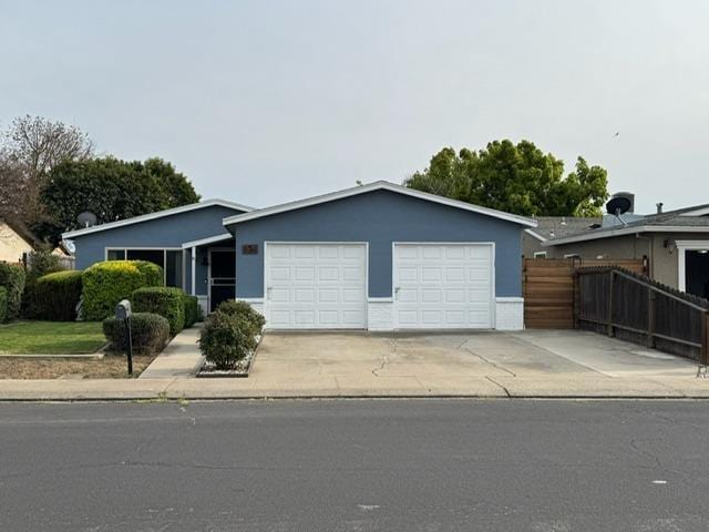 854 La Playa Ct, Manteca, CA 95336 - view of front of house with fence, stucco siding, a garage, and concrete driveway