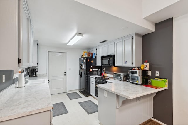 100 Rosewood Cir, Madera, CA 93637 - kitchen featuring light floors, a peninsula, a toaster, visible vents, and black appliances