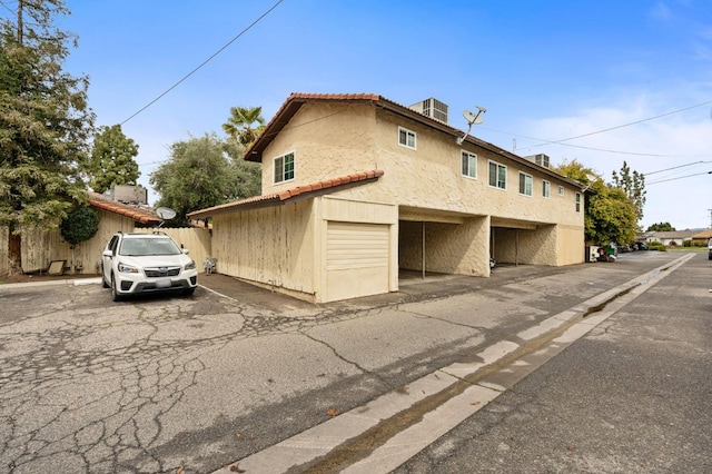 1063 Pierce Dr, Clovis, CA 93612 - view of side of home with fence, a tile roof, stucco siding, and covered and uncovered parking