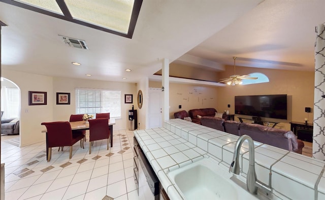 7186 N Gregory Ave, Fresno, CA 93722 - living room with ceiling fan, light tile patterned floors, lofted ceiling, arched walkways, and recessed lighting