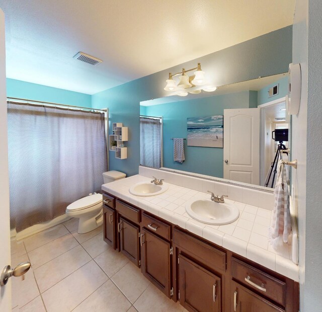 7186 N Gregory Ave, Fresno, CA 93722 - full bathroom with tile patterned floors, toilet, double vanity, and curtained shower