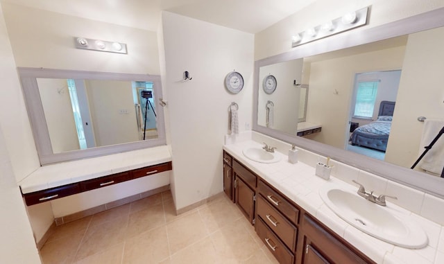 7186 N Gregory Ave, Fresno, CA 93722 - ensuite bathroom featuring double vanity, baseboards, and tile patterned floors