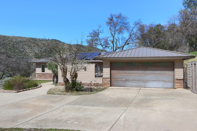 view of front of home featuring stone siding, metal roof, and a standing seam roof