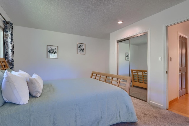 carpeted bedroom featuring recessed lighting, baseboards, a closet, and a textured ceiling