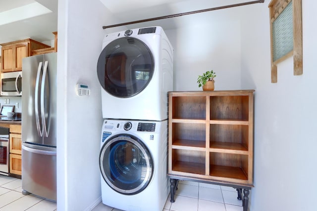 laundry area with stacked washer and dryer, laundry area, and light tile patterned flooring