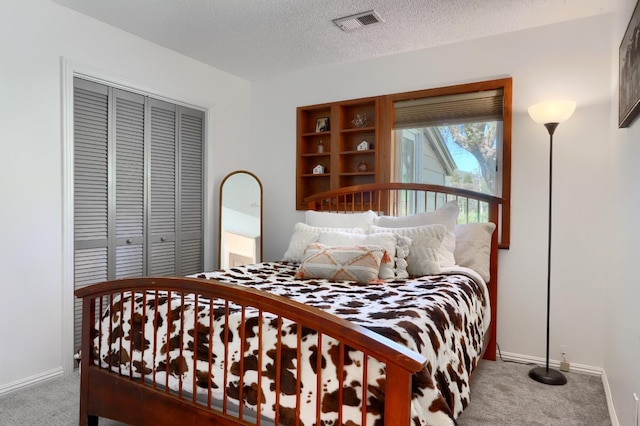 carpeted bedroom featuring a closet, baseboards, a textured ceiling, and visible vents