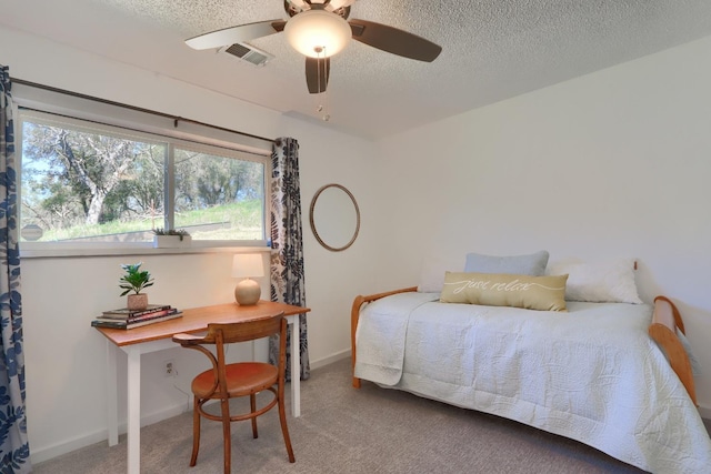 bedroom with carpet flooring, a textured ceiling, baseboards, visible vents, and ceiling fan