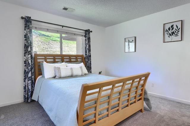 carpeted bedroom with baseboards, visible vents, and a textured ceiling