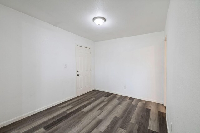 unfurnished room featuring dark wood finished floors and baseboards