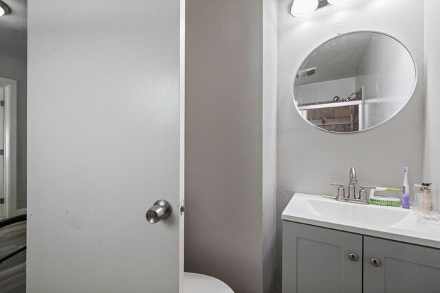 bathroom featuring toilet, vanity, and visible vents