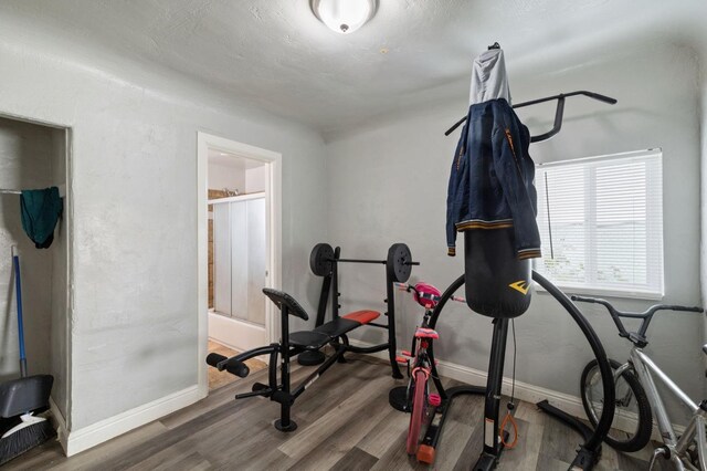 exercise area with baseboards and wood finished floors