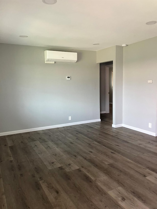 3012 N Fruit, Fresno, CA 93705 - empty room with a wall mounted air conditioner, dark wood finished floors, and baseboards