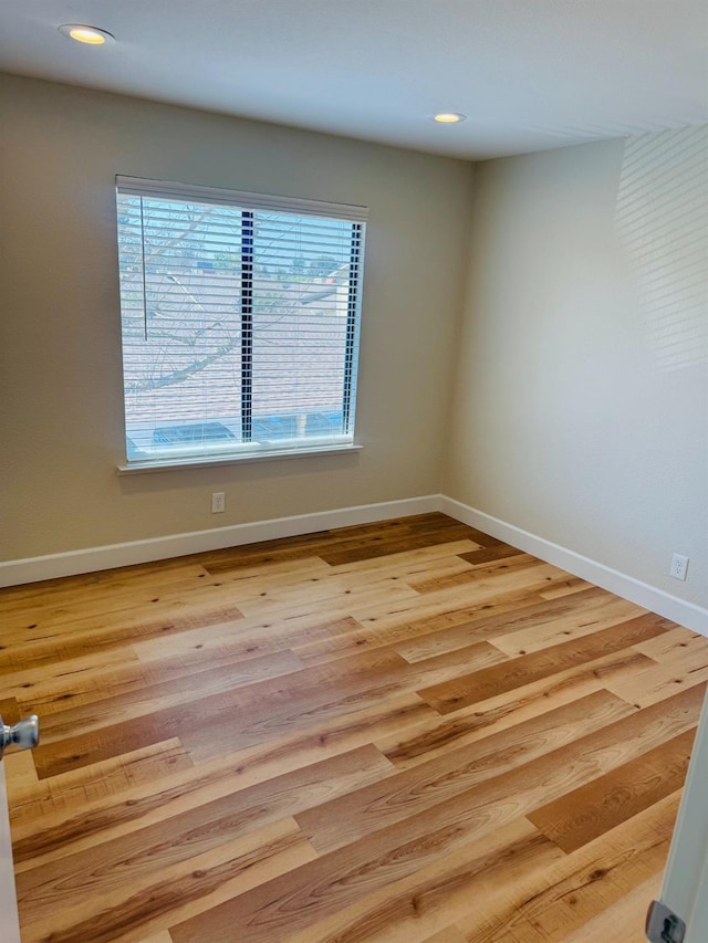 spare room featuring baseboards, recessed lighting, and wood finished floors