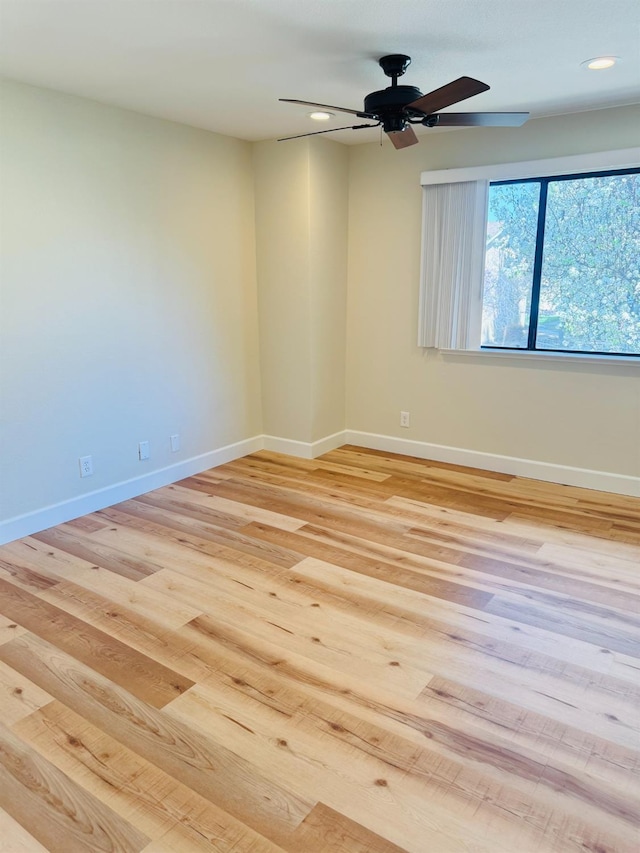spare room featuring a ceiling fan, light wood-style floors, recessed lighting, and baseboards