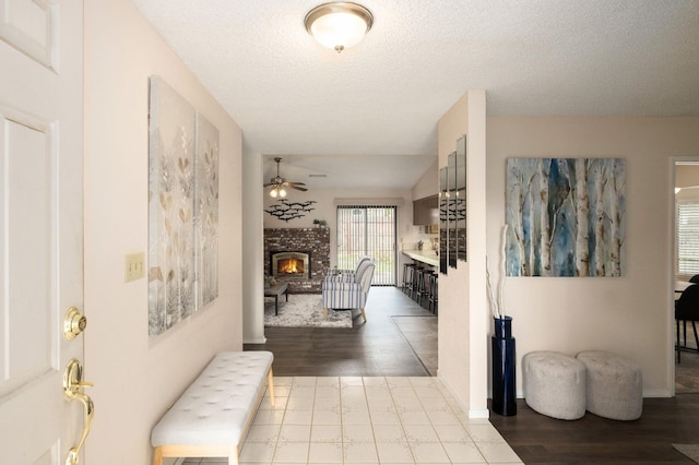 corridor with a textured ceiling, baseboards, and wood finished floors