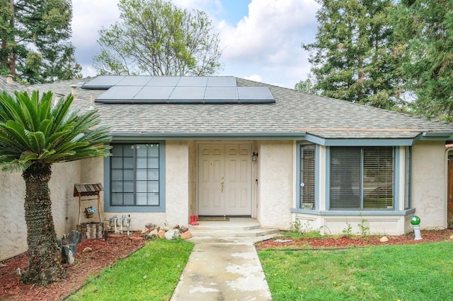 exterior space featuring stucco siding, solar panels, and roof with shingles