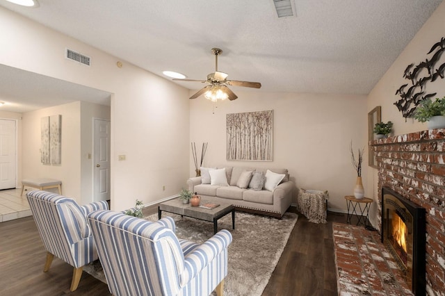 living room with visible vents, a ceiling fan, wood finished floors, and a fireplace