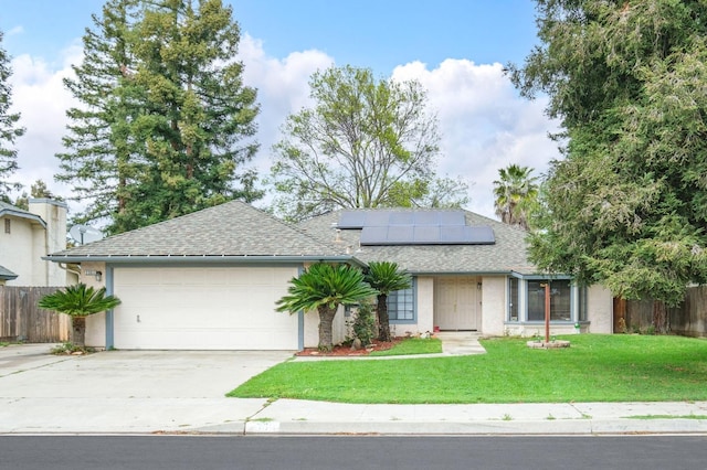 ranch-style house featuring solar panels, a garage, fence, a front lawn, and driveway