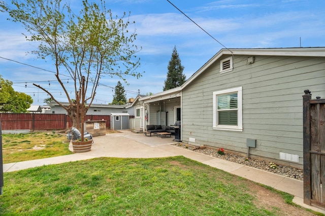 back of property with fence, outdoor lounge area, an outdoor structure, a yard, and a patio area