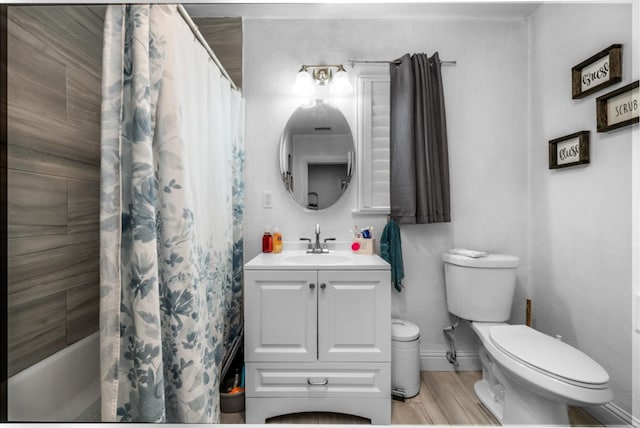 full bathroom with vanity, shower / tub combo with curtain, toilet, baseboards, and wood finished floors