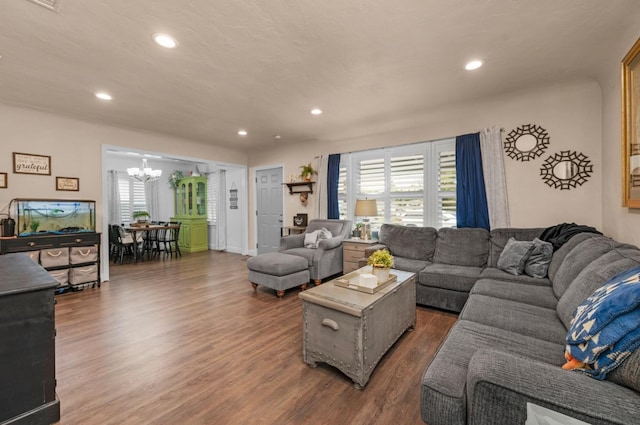 living area with an inviting chandelier, dark wood-type flooring, and recessed lighting