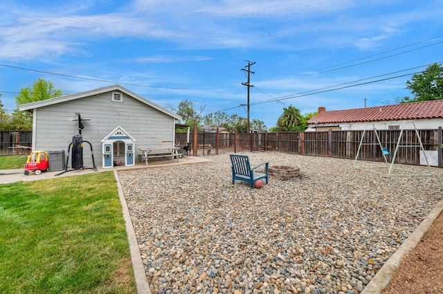 view of yard with a fenced backyard, a fire pit, and a patio area