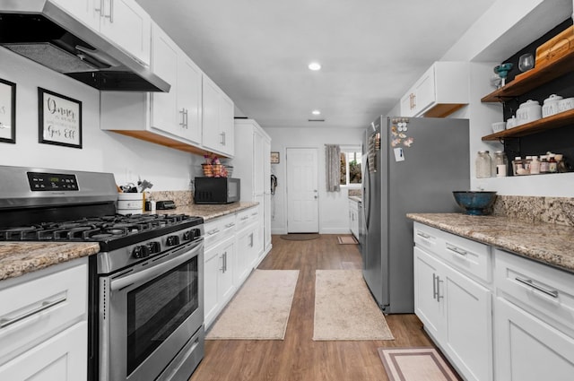 kitchen with under cabinet range hood, white cabinetry, wood finished floors, and stainless steel appliances