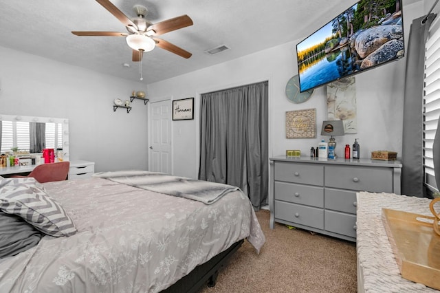 carpeted bedroom with visible vents and ceiling fan