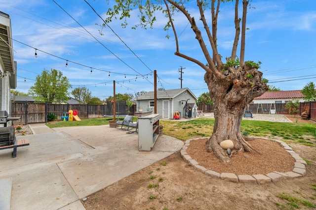 view of yard with an outdoor structure, a fenced backyard, and a patio area