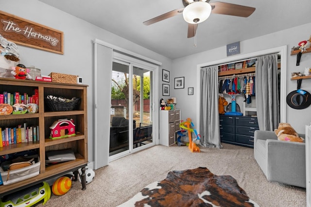recreation room with ceiling fan and carpet