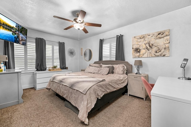 bedroom featuring a textured ceiling, multiple windows, ceiling fan, and light colored carpet