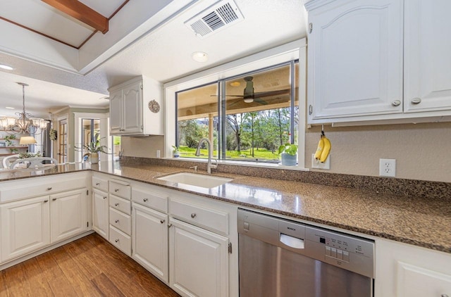 kitchen featuring visible vents, light wood finished floors, dishwasher, dark stone counters, and a sink