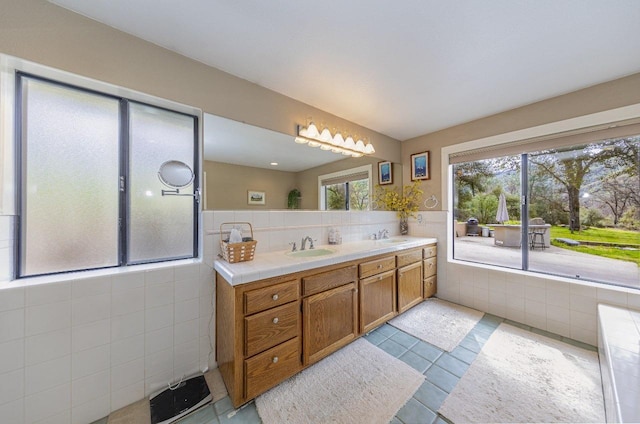 bathroom with tile walls, double vanity, and a sink
