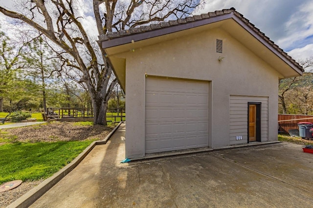 detached garage with driveway and fence