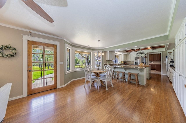 dining room featuring baseboards, wood finished floors, and crown molding