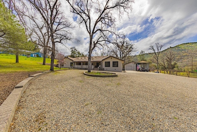 ranch-style home featuring driveway, fence, and a mountain view