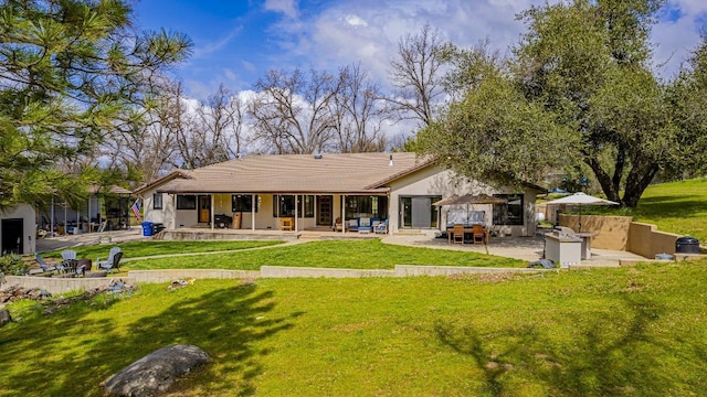 back of property featuring a patio, stucco siding, fence, and a yard