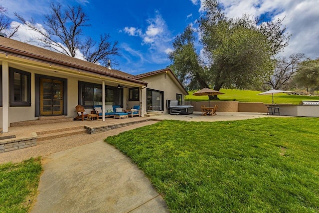 view of yard featuring a hot tub, an outdoor living space, and a patio