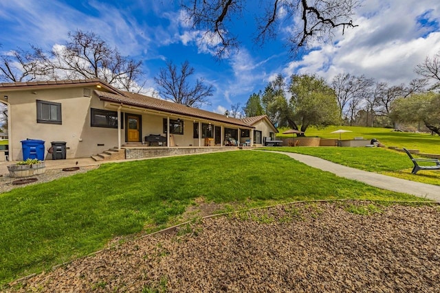 back of property featuring stucco siding, a tiled roof, a yard, and a patio area
