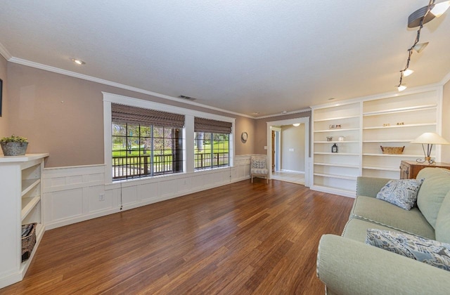 living room with a wainscoted wall, visible vents, wood finished floors, and ornamental molding