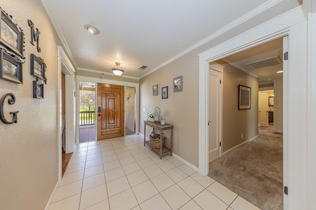 foyer featuring light tile patterned flooring, visible vents, and crown molding