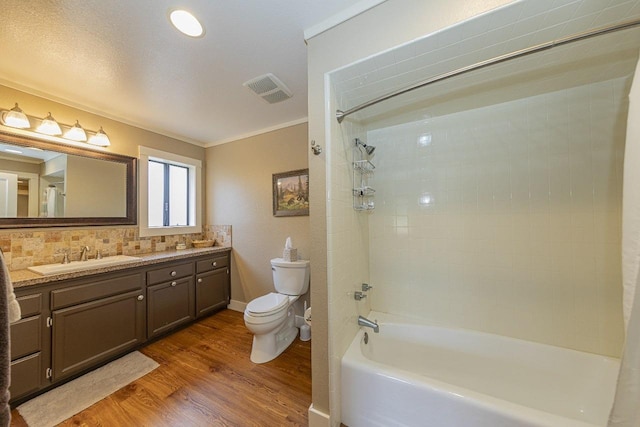 full bathroom featuring toilet, vanity, wood finished floors, tub / shower combination, and visible vents