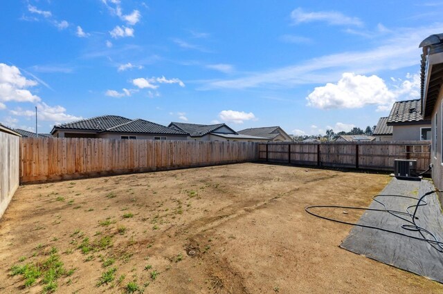 view of yard with central AC and a fenced backyard