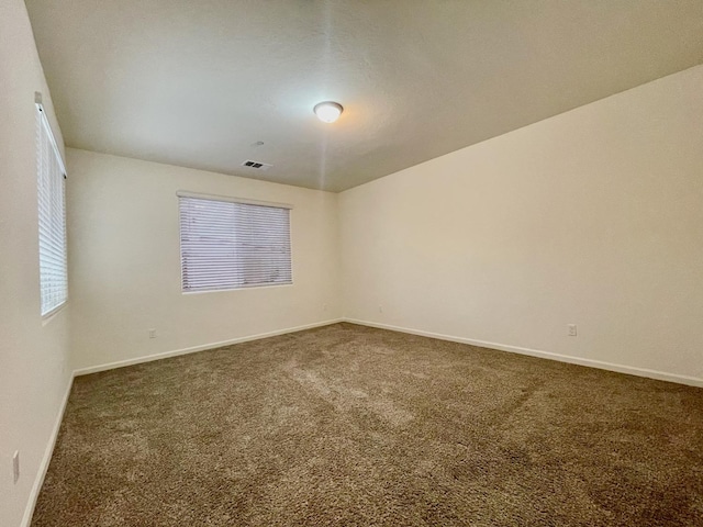 unfurnished room featuring carpet, baseboards, and visible vents