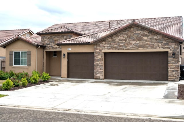 view of front of property featuring a tile roof, concrete driveway, stucco siding, and an attached garage