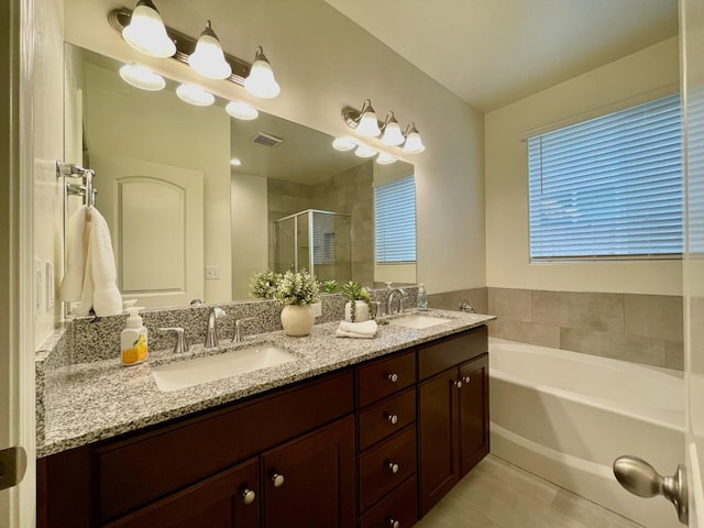 bathroom featuring a bath, double vanity, a sink, and a stall shower