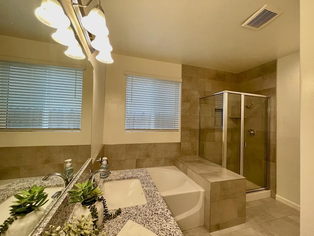 full bathroom featuring a stall shower, visible vents, a notable chandelier, and a garden tub