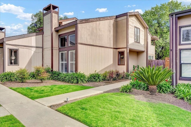 view of side of property featuring a yard, a chimney, and fence