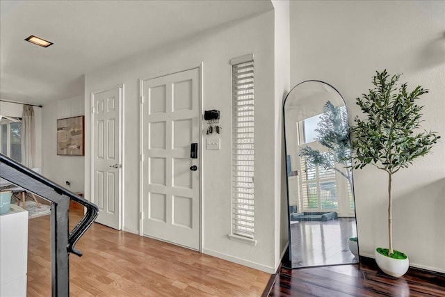 foyer entrance with baseboards and light wood-style floors