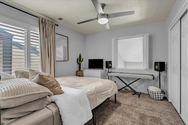 carpeted bedroom featuring a closet, ceiling fan, and visible vents